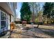 Landscaped backyard featuring gravel fire pit, mature trees, and wooded backdrop for outdoor relaxation and enjoyment at 1971 Commonwealth Way, Grayson, GA 30017