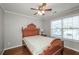 Cozy bedroom with a ceiling fan, hardwood floors, and natural light from the window at 1971 Commonwealth Way, Grayson, GA 30017