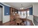 Cozy dining room features wood floors, a hutch, chair rail detail, and a bay window with floral curtains at 1971 Commonwealth Way, Grayson, GA 30017