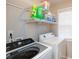 Functional laundry room with modern washer and dryer, shelving, a window, and neutral color scheme at 1971 Commonwealth Way, Grayson, GA 30017