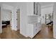 Bright hallway with hardwood floors leads to a bedroom and a staircase with white cabinets and a marble countertop at 2550 Belaire Dr, Cumming, GA 30041