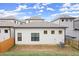 Backyard view of a white, modern home, showcasing the lawn and fencing at 118 Village Green Ave, Woodstock, GA 30189