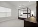 Spacious bedroom with a four-poster bed, neutral tones, ample natural light from a large window, and elegant furnishings at 118 Village Green Ave, Woodstock, GA 30189