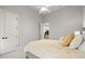 Bedroom features plush bed, white doors, and view of the staircase at 118 Village Green Ave, Woodstock, GA 30189