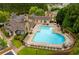 Aerial shot of a large community pool surrounded by lounge chairs and lush landscaping, perfect for relaxation at 118 Village Green Ave, Woodstock, GA 30189