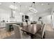 Open-concept dining area featuring modern chandelier, skylight, and seamless connection to the kitchen and living room at 118 Village Green Ave, Woodstock, GA 30189