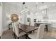 Open-concept dining area featuring modern chandelier, skylight, and seamless connection to the kitchen at 118 Village Green Ave, Woodstock, GA 30189