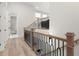 Bright hallway features light wood floors and decorative iron and wood staircase at 118 Village Green Ave, Woodstock, GA 30189