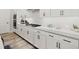 Modern kitchen featuring white cabinetry, stainless steel appliances, and quartz countertops at 118 Village Green Ave, Woodstock, GA 30189
