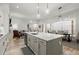 Open-concept kitchen with a large island flowing into the dining and living areas, perfect for entertaining at 118 Village Green Ave, Woodstock, GA 30189