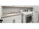 Bright laundry room boasts granite counters, cabinets, sink, washer and dryer at 118 Village Green Ave, Woodstock, GA 30189