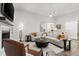 Open-concept living room featuring a modern ceiling fan, fireplace, and seamless connection to the backyard at 118 Village Green Ave, Woodstock, GA 30189