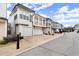 Street view of attractive townhomes featuring garages and architectural details at 118 Village Green Ave, Woodstock, GA 30189