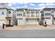 Charming townhomes with garages and stylish architectural details on a tree-lined street at 118 Village Green Ave, Woodstock, GA 30189