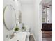 A modern bathroom features a round mirror and a view into the living room at 1625 Watercrest Dr, Cumming, GA 30041