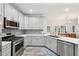 A kitchen features stainless steel appliances, gray cabinets, and mosaic tile backsplash at 1625 Watercrest Dr, Cumming, GA 30041