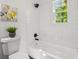 Modern bathroom with a tiled shower and tub combination featuring updated fixtures and a window view at 169 Wadley Nw St, Atlanta, GA 30314