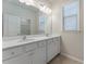 A bathroom showcasing double sinks, a large mirror, and a bright window at 3218 Hidden Valley Cir, Lawrenceville, GA 30044