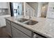 Close up of kitchen island with dual stainless steel sinks, granite countertops, and stainless dishwasher at 3218 Hidden Valley Cir, Lawrenceville, GA 30044