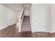 View of the home's staircase with carpeted steps and wood handrail, next to a white door and light hardwood flooring at 3218 Hidden Valley Cir, Lawrenceville, GA 30044