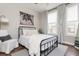 Bright bedroom featuring metal bed frame, white duvet, and large windows with white curtains at 472 Burton Dr, Alpharetta, GA 30009