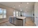 Kitchen island provides a central sink and dishwasher, with stainless steel appliances, and open floor plan at 116 Dalston Cv, Stockbridge, GA 30281