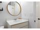 A bathroom featuring a sink with a large round mirror and modern hardware at 120 Woodford Ln, Canton, GA 30115