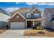 Beautiful two-story home featuring stone accents, a two-car garage, and a well-manicured front yard at 120 Woodford Ln, Canton, GA 30115