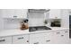 Close up of a white kitchen counter with black hardware and gas cooktop at 120 Woodford Ln, Canton, GA 30115