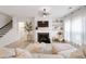 Inviting living room featuring a cozy fireplace, TV, staircase, and light wood floors at 120 Woodford Ln, Canton, GA 30115