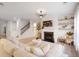 Inviting living room featuring a cozy fireplace, TV, staircase, and light wood floors at 120 Woodford Ln, Canton, GA 30115