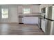 A modern kitchen featuring white cabinets, stainless steel appliances, and luxury vinyl plank flooring at 15 Heyman Dr, Covington, GA 30016