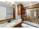 This bathroom includes a granite topped vanity and a tub and shower combination behind glass at 2190 Rugby Ave, Atlanta, GA 30337