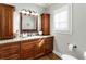 Bathroom vanity with dark wood cabinets, granite countertop, and decorative mirror at 2190 Rugby Ave, Atlanta, GA 30337