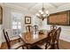 Formal dining room featuring a large wood table, wainscoting, plantation shutters, and elegant chandelier at 2190 Rugby Ave, Atlanta, GA 30337