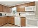 Bright kitchen showcasing wood cabinets, white appliances, granite countertops, and a garden window at 3653 Memorial Nw Pkwy, Kennesaw, GA 30152