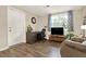 Living room featuring wood-look floors, desk, window, and white trim at 3653 Memorial Nw Pkwy, Kennesaw, GA 30152