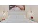 A large bed is placed in front of artwork above the headboard, accompanied by stylish sconces and end tables at 4106 Pine Heights Ne Dr, Atlanta, GA 30324