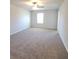 This bedroom features neutral walls, carpet, a ceiling fan, and a window at 55 Heyman Dr, Covington, GA 30016