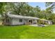 Rear exterior showcasing the home, patio area, and expansive lawn surrounded by mature trees at 3306 Briarcliff Ne Rd, Atlanta, GA 30345