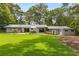 A spacious backyard with a well-kept lawn, patio seating area, and mature trees at 3306 Briarcliff Ne Rd, Atlanta, GA 30345