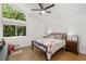A well lit bedroom has a ceiling fan, an oversized window and hardwood floors at 3306 Briarcliff Ne Rd, Atlanta, GA 30345