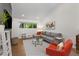 Comfortable living room with a gray sofa, orange chair, and a glass coffee table near a large window at 3306 Briarcliff Ne Rd, Atlanta, GA 30345