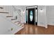 Elegant foyer featuring hardwood floors, staircase with white railings, and a stylish front door at 4990 Sawgrass Nw Pl, Acworth, GA 30102