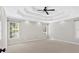 Spacious main bedroom featuring tray ceiling, neutral paint, carpet, and plenty of natural light at 4990 Sawgrass Nw Pl, Acworth, GA 30102