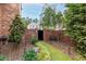 Private backyard space featuring a brick wall, a charming bench and manicured landscaping at 8025 Georgetown Cir, Suwanee, GA 30024