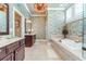 Elegant bathroom featuring dual vanities, soaking tub, and a decorative wallpaper at 8025 Georgetown Cir, Suwanee, GA 30024