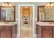 Well-lit bathroom featuring dual vanities with a view into the hallway at 8025 Georgetown Cir, Suwanee, GA 30024
