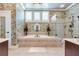 Primary bath showcasing a large soaking tub, tile flooring, and decorative wallpaper at 8025 Georgetown Cir, Suwanee, GA 30024