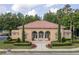 Clubhouse with a red tile roof, arched windows, manicured landscaping, and American flags at 8025 Georgetown Cir, Suwanee, GA 30024